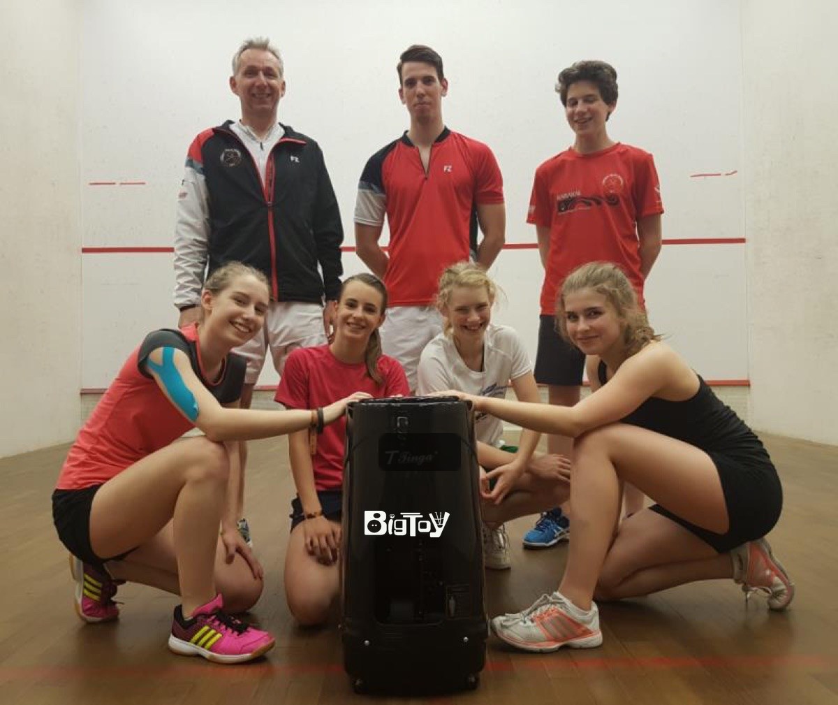Junior squash players with a BigToy training machine on court